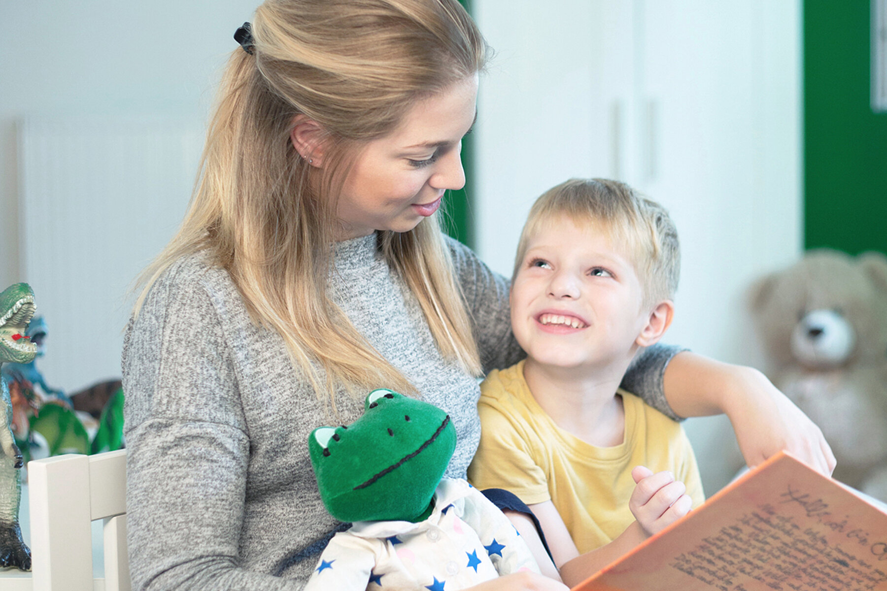 Kleiner Junge mit Mutter und Plüschfrosch der Klingelhose